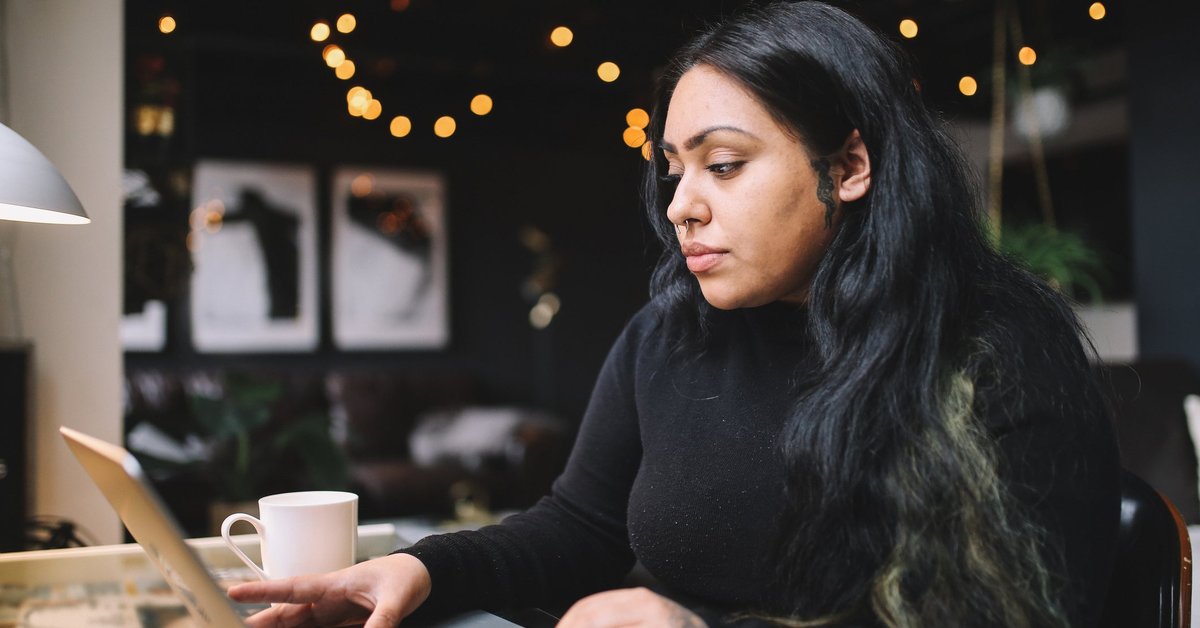 A person uses a laptop at a desk at home.