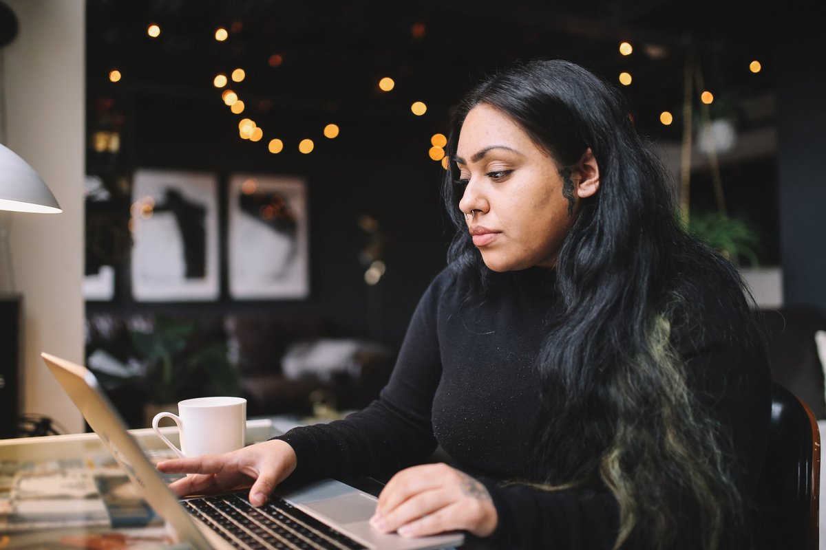 A person uses a laptop at a desk at home.