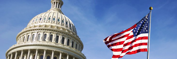 Capitol building with American flag in foreground.