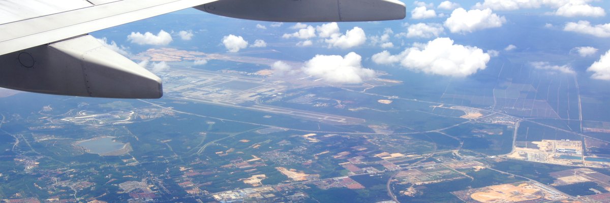 The wing of an airplane high above the earth.