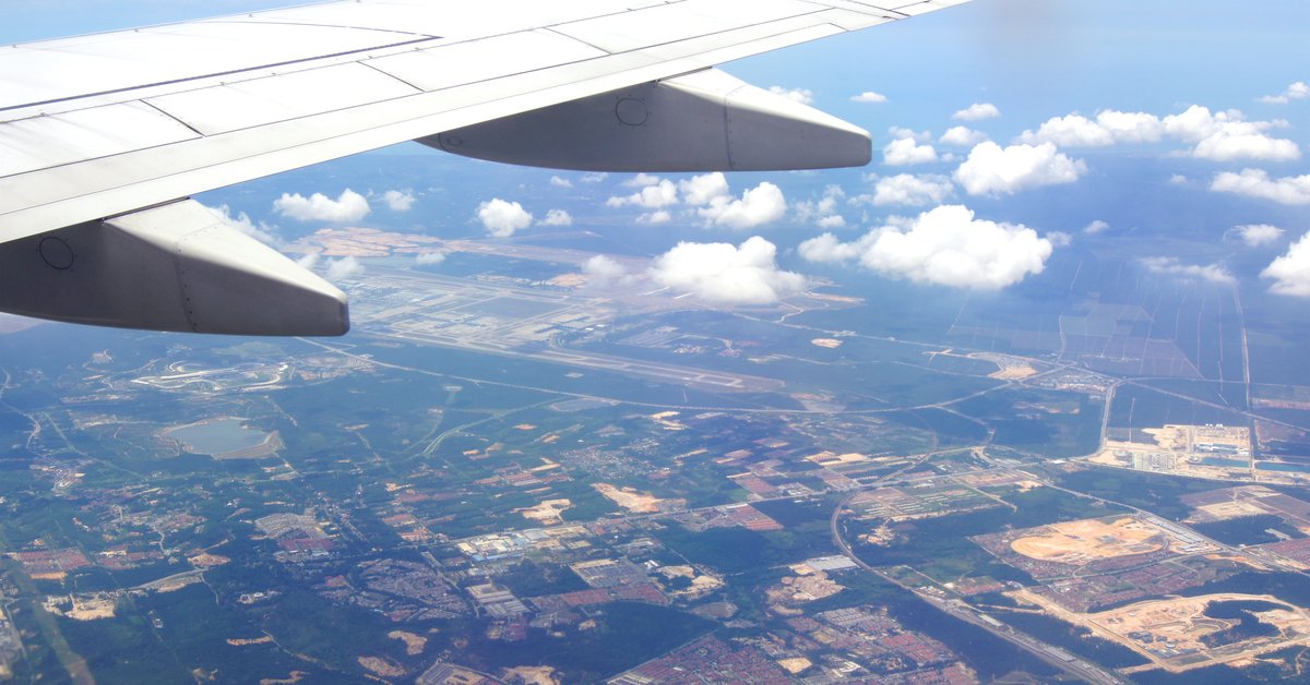 The wing of an airplane high above the earth.