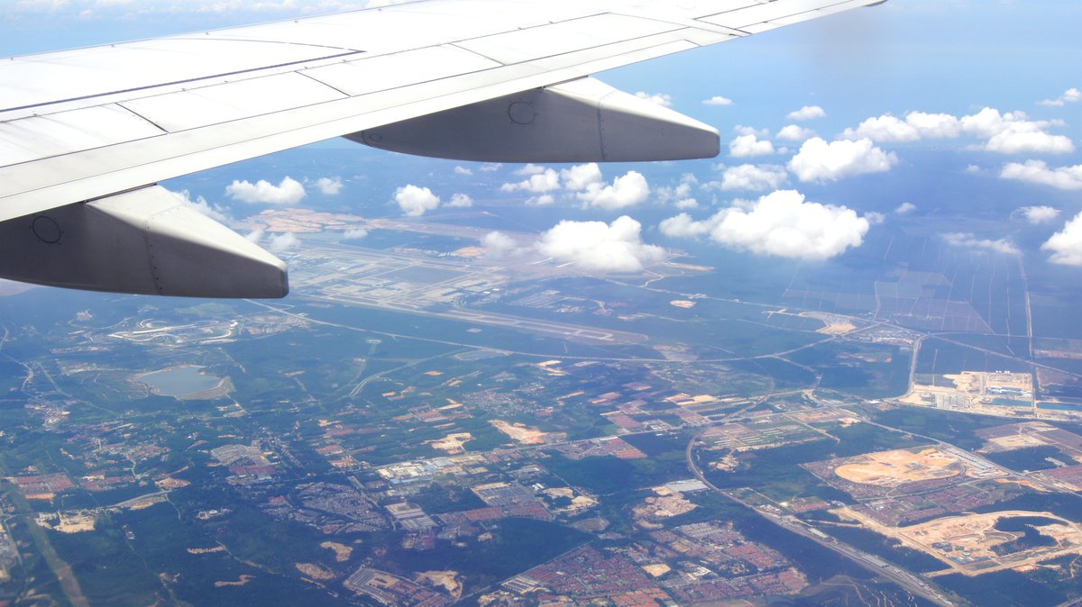 The wing of an airplane high above the earth.