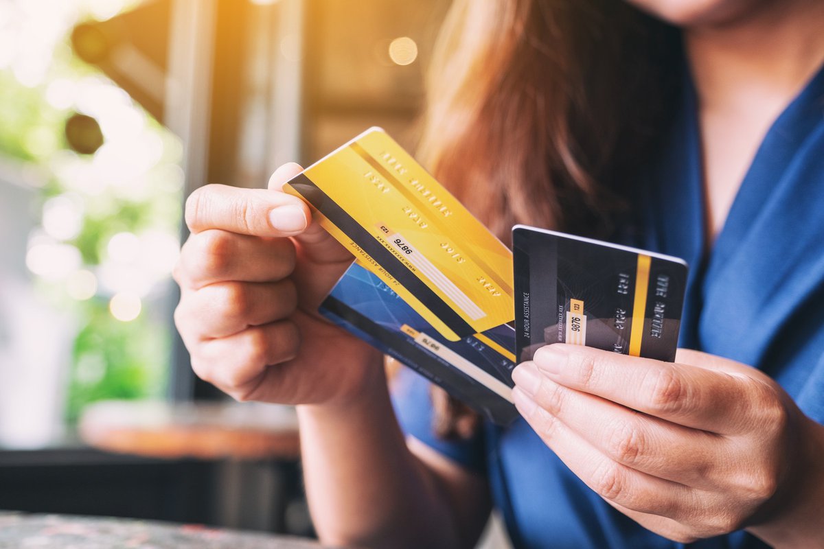 Woman choosing and removing one credit card from a set of three.