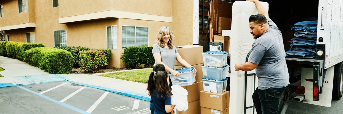 A multigenerational family loads items onto a moving truck.