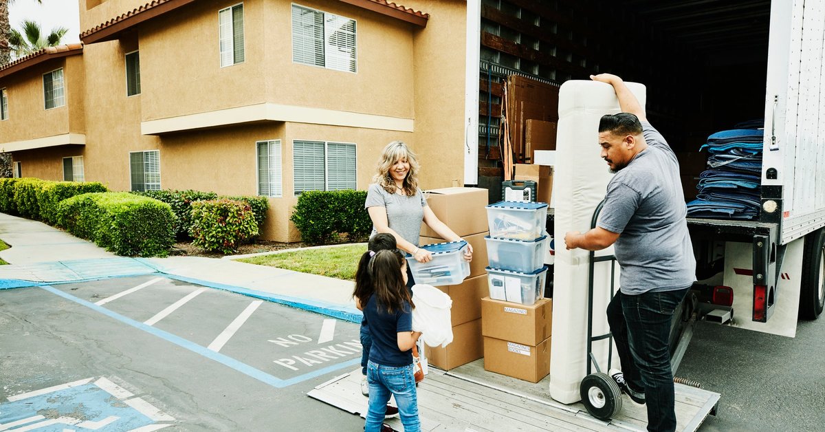 A multigenerational family loads items onto a moving truck.