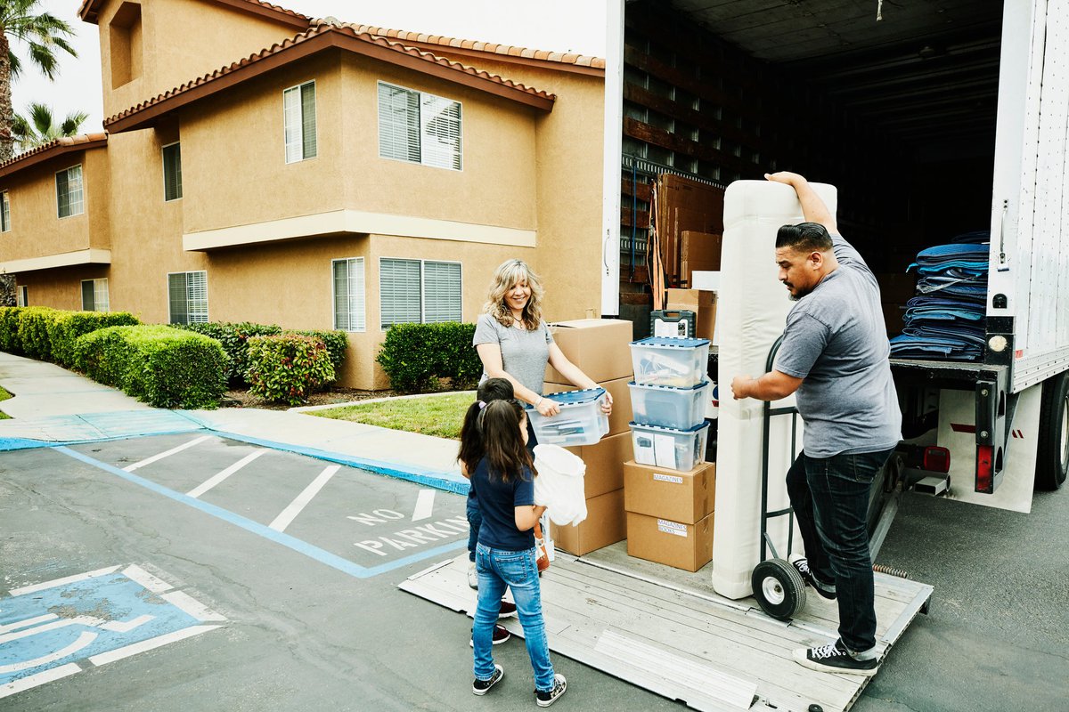 A multigenerational family loads items onto a moving truck.