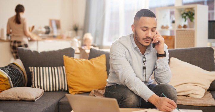 Man on the phone doing paperwork at home