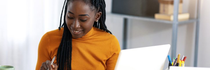 Happy woman makes a calculation at her desk