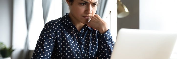 Concerned woman looks at laptop screen