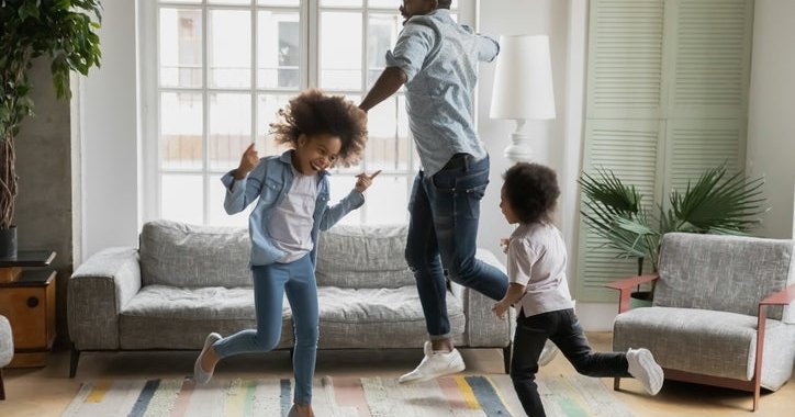 Man and kids dance around new home.