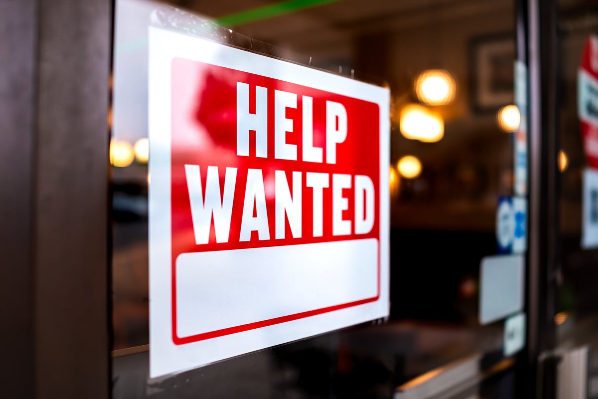 A Help Wanted sign in a store window.