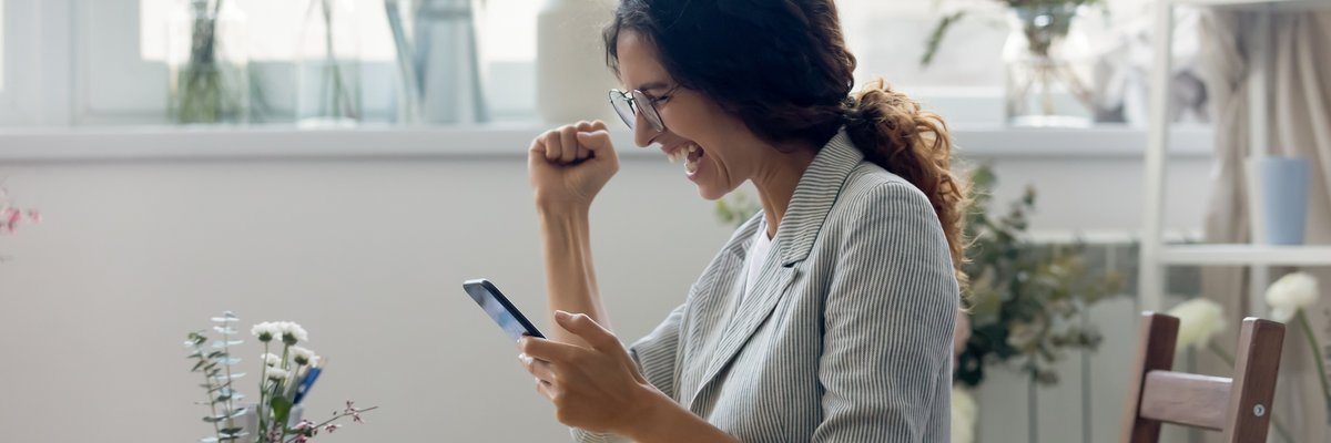 A person is excited while looking at their phone screen.
