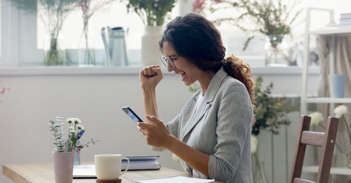 A person is excited while looking at their phone screen.