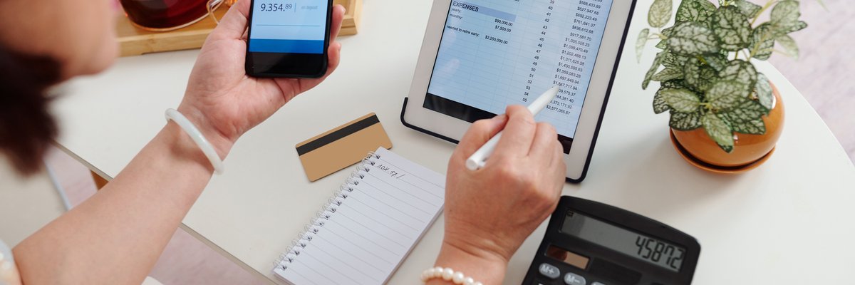 An adult checks their online brokerage account using their tablet and smartphone.