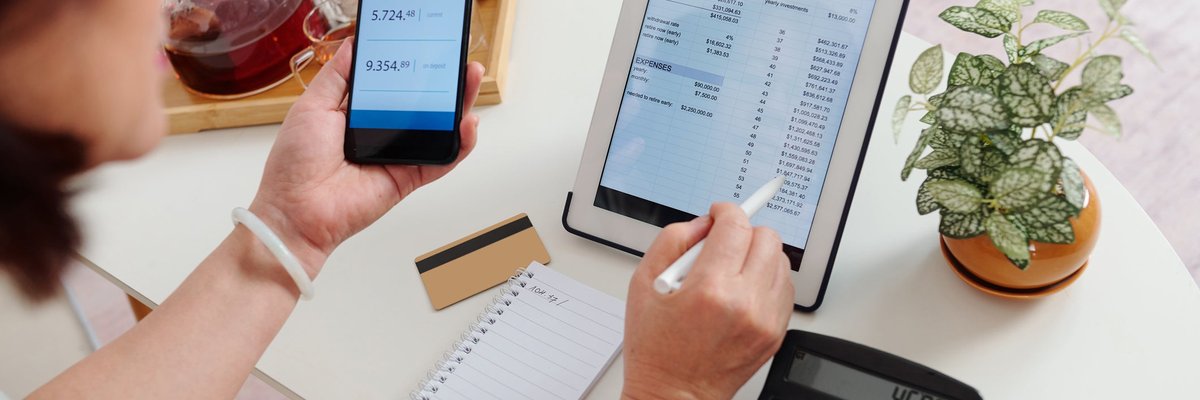 An adult checks their online brokerage account using their tablet and smartphone.