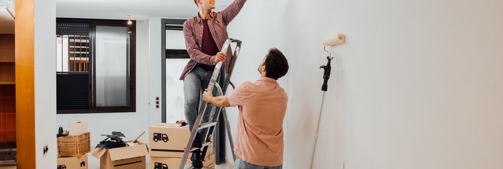 Young couple fixes a light bulb as they move into their new house.