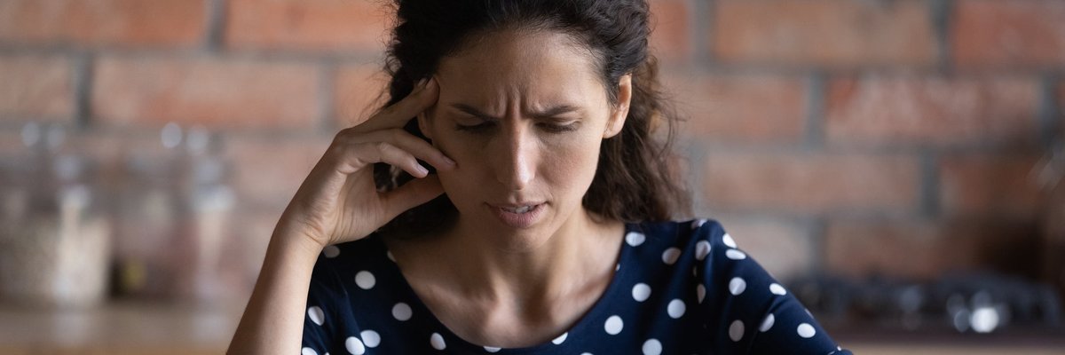 An upset person with a creased brow looks at their smartphone screen.