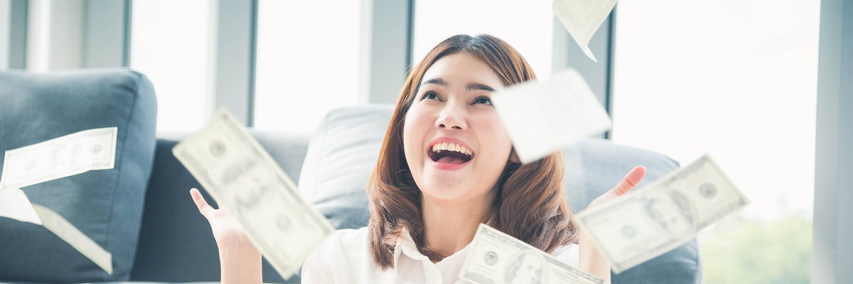 Person expressing joy as cash rains down around them.