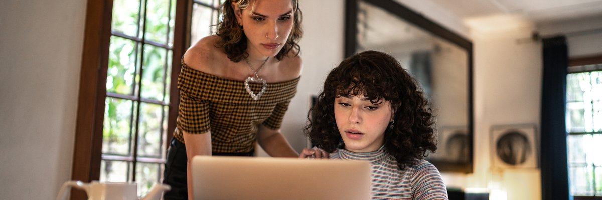 A concerned couple calculates their home finances together using a laptop.