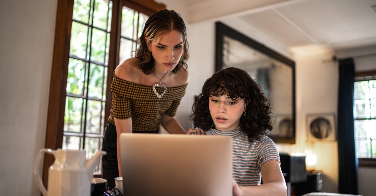 A concerned couple calculates their home finances together using a laptop.