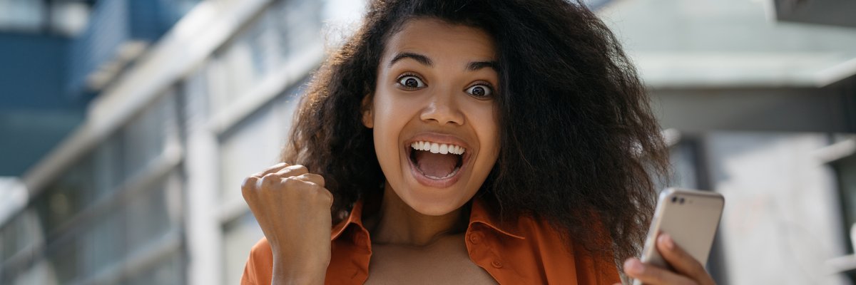 Person ecstatic with raised clenched fists and big smile.