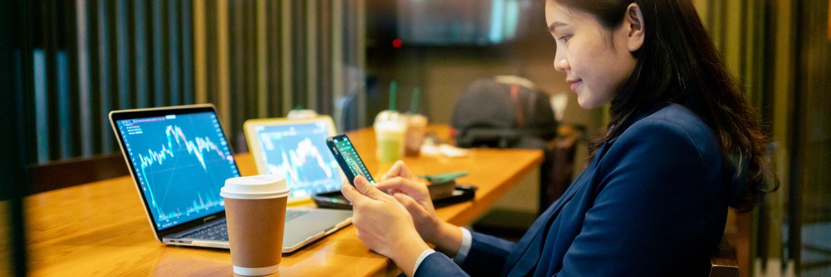 A business worker looks at crypto or stock graphs on their laptop.