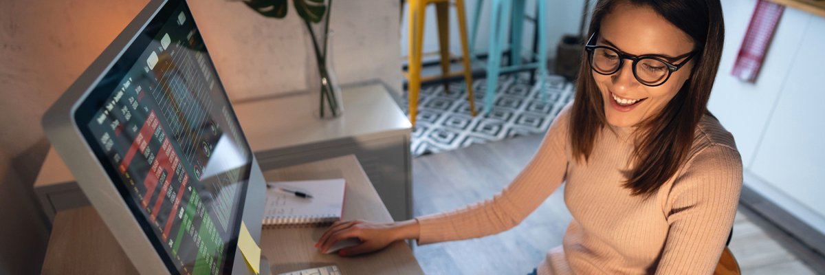 A young adult tracks and trades stocks on a computer.