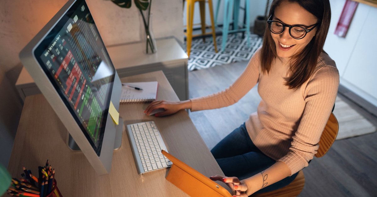 A young adult tracks and trades stocks on a computer.