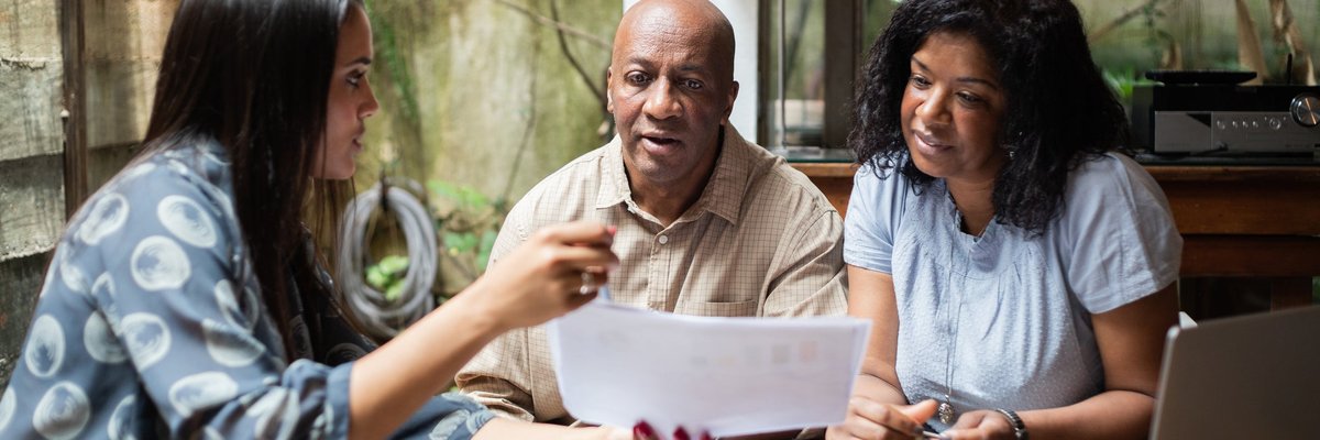 A couple meets with a financial advisor in their home.