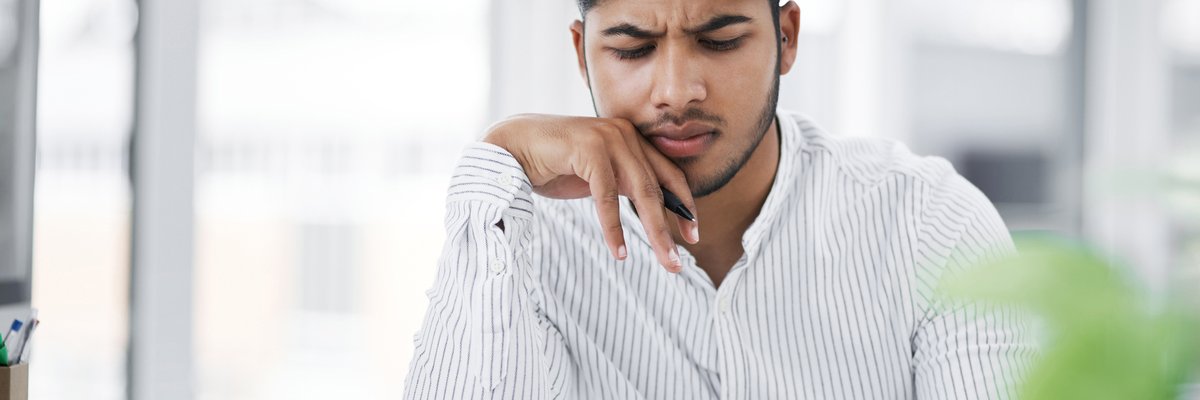 A young man with furrowed brow uses a calculator