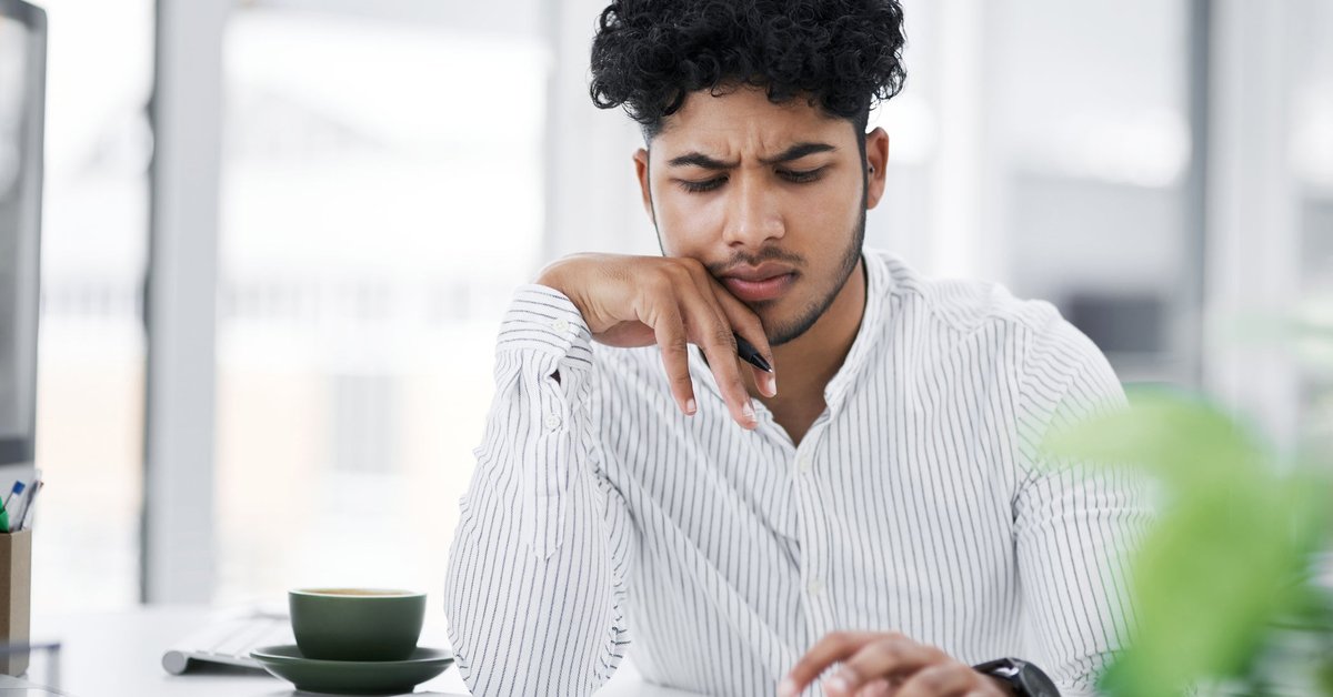 A young man with furrowed brow uses a calculator