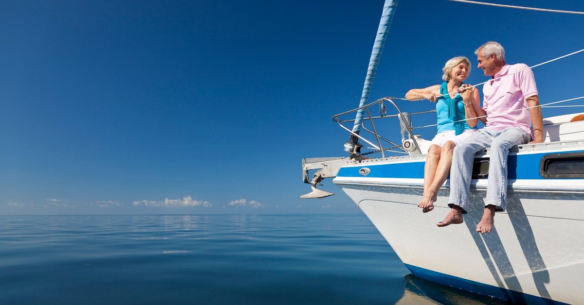 Smiling man and woman sitting on yacht