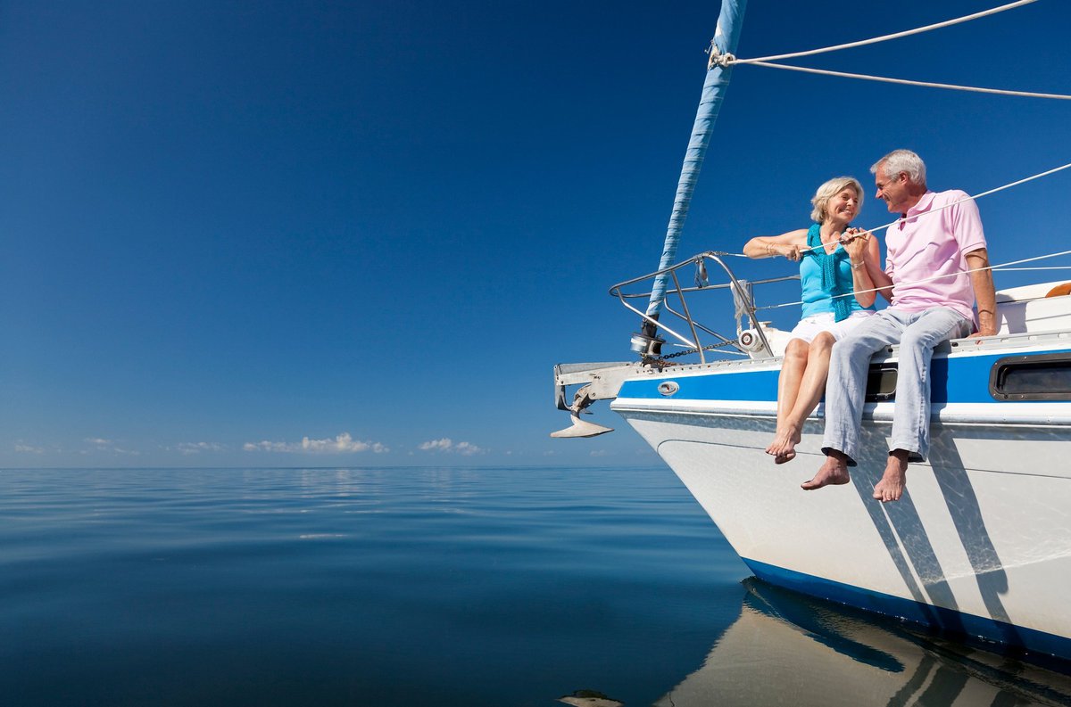 Smiling man and woman sitting on yacht