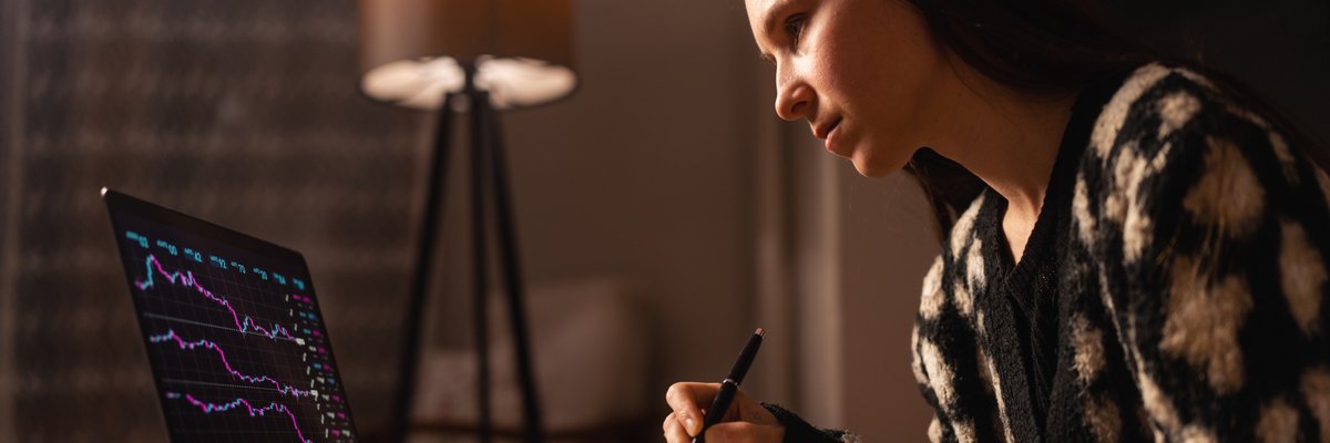 A woman gazes at a computer screen to check crypto prices
