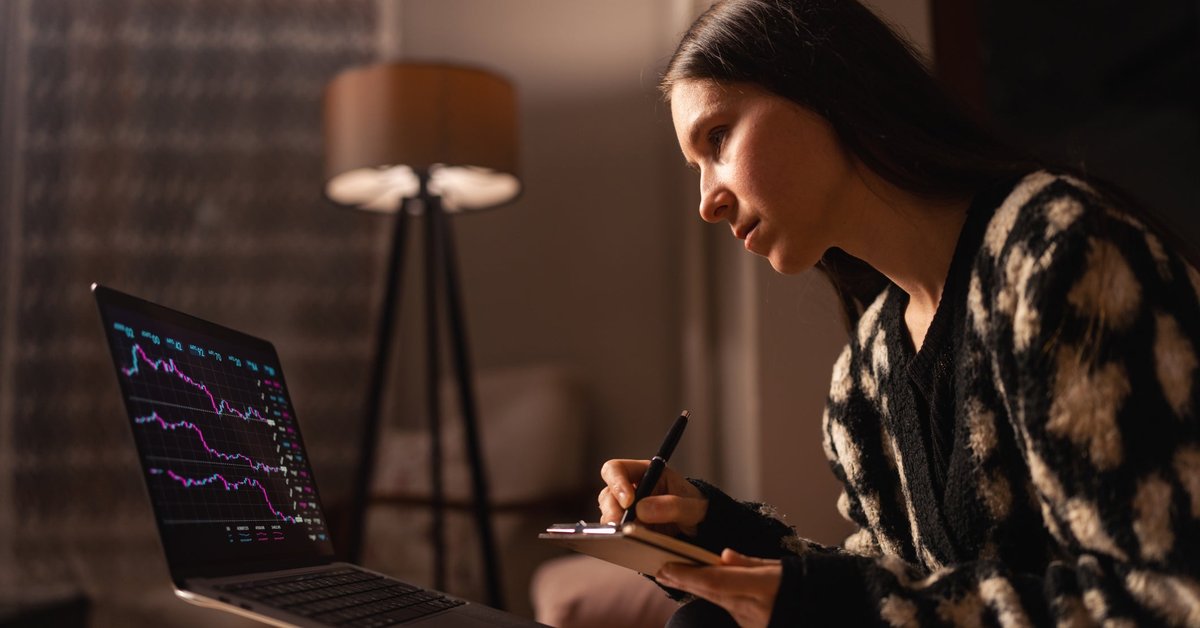 A woman gazes at a computer screen to check crypto prices