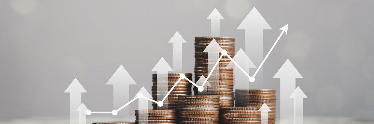 Various piles of coins with upward arrows and an upward trending line graph laid overtop.
