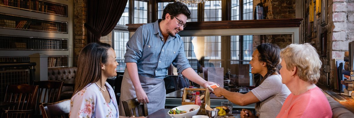 Family pays for restaurant meal with a credit card.