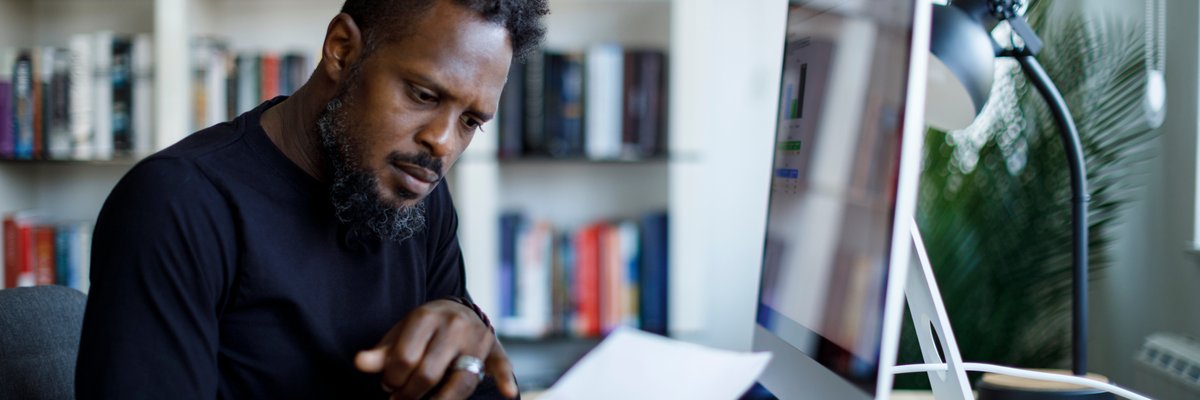 Man appears shocked or concerned by what he reads on paper.