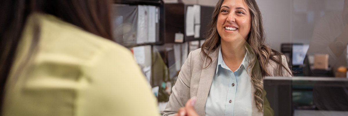 Female bank teller smiling at customer.