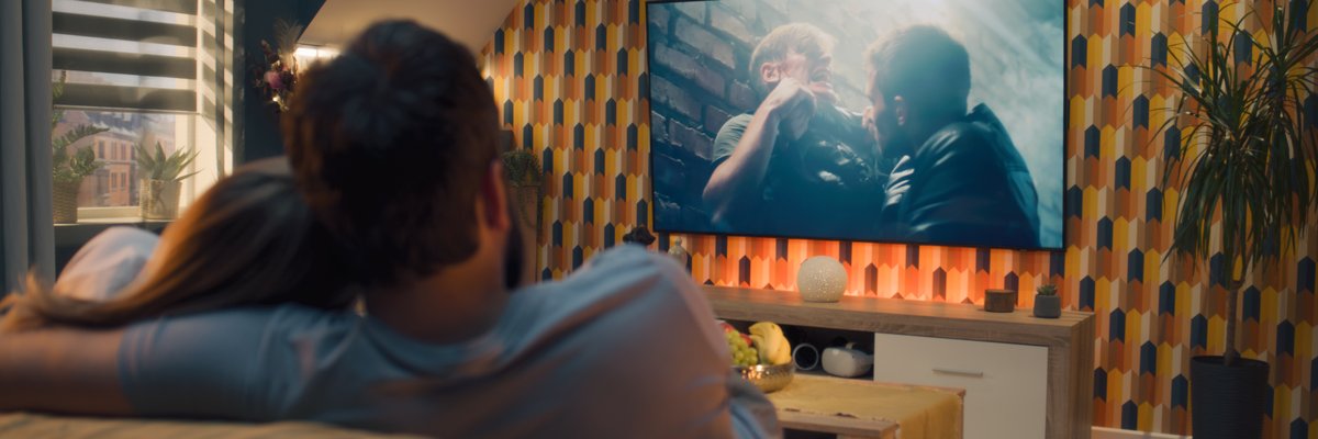 Couple watching movie together from the couch.