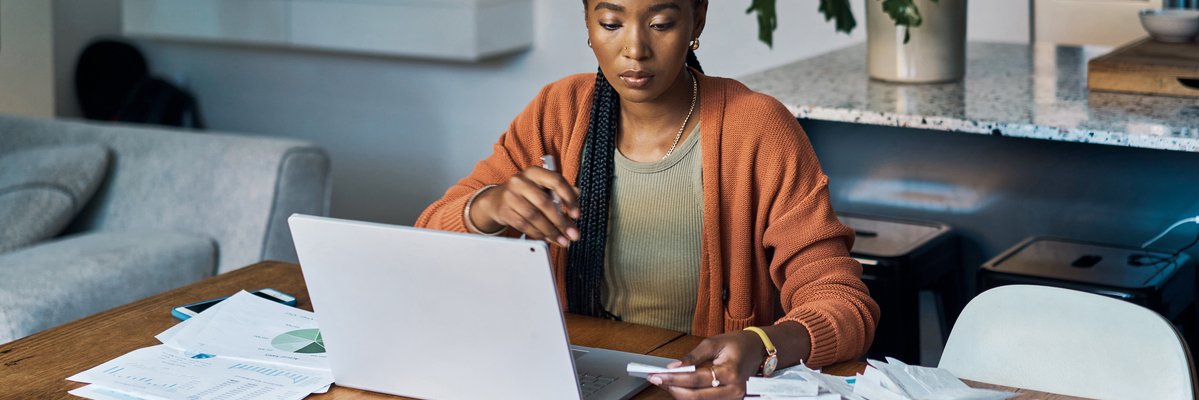 Person with laptop, bills, paperwork