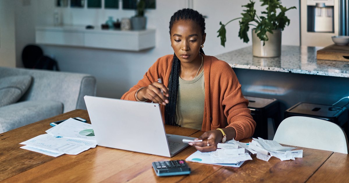 Person with laptop, bills, paperwork