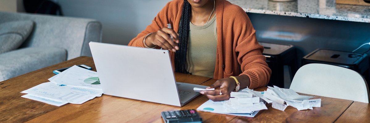 Person with laptop, bills, paperwork