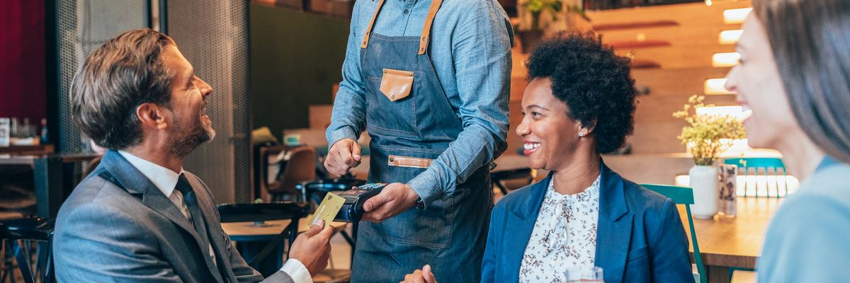 Professional man pays for business meal with credit card at a restaurant.