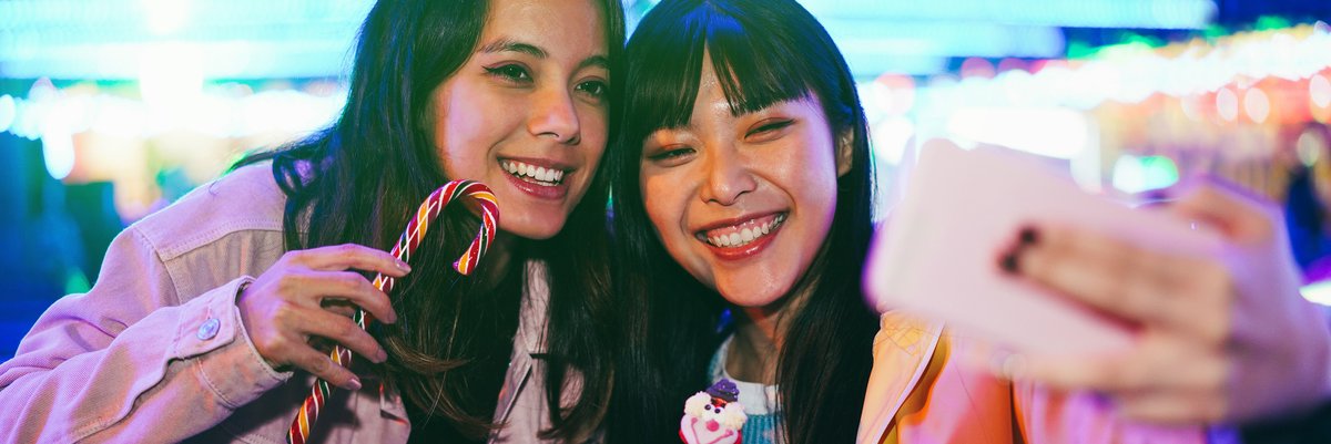 Two young adults taking selfies on vacation.