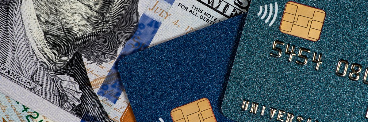 Cash and credit cards laying in a pile together.