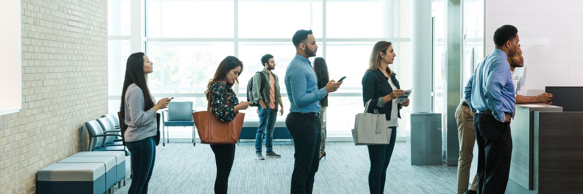 Customers in line for their turn with bank teller.