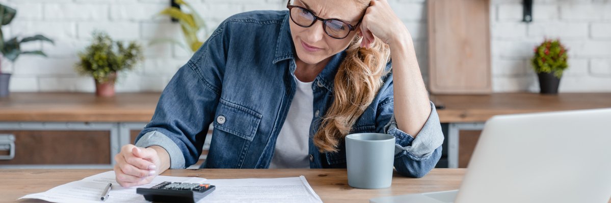 Woman sitting at table making calculations