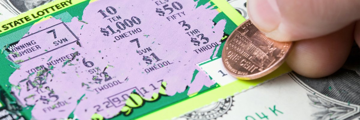 Hand scratching a lottery ticket.