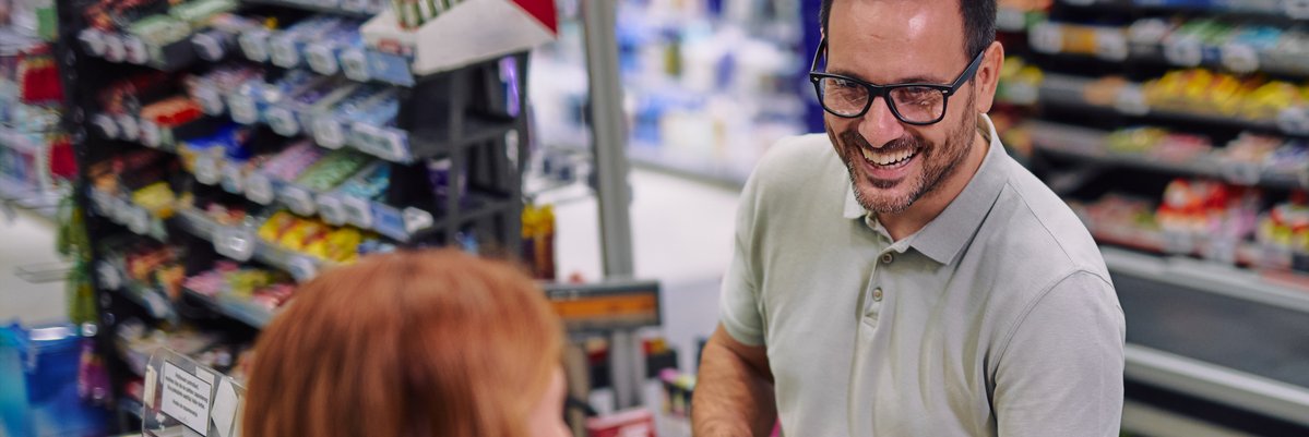 Person paying in the grocery store checkout with a credit card.